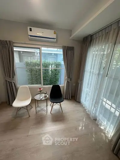 Bright living room with modern chairs and large windows, perfect for relaxation.