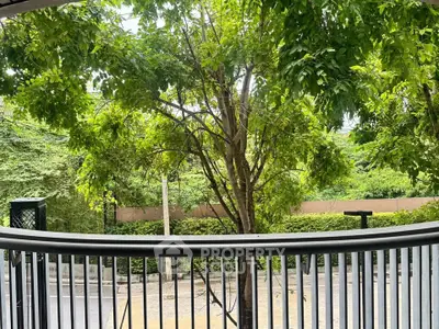 Charming balcony view with lush greenery and street scenery, perfect for relaxation and enjoying nature.