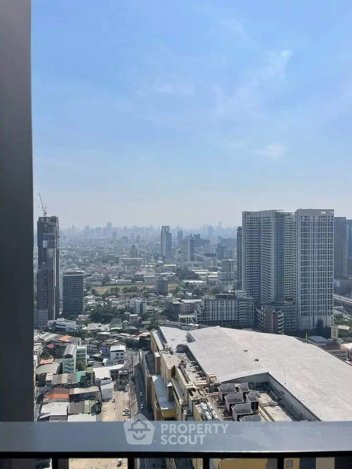 Stunning cityscape view from high-rise balcony showcasing urban skyline and clear blue sky.