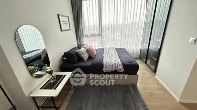 Modern bedroom with large window and stylish decor in a high-rise apartment.