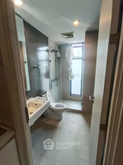 Modern bathroom with sleek fixtures and natural light from window.