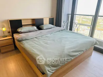 Spacious bedroom with modern decor and stunning city view from large windows.