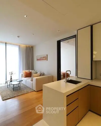 Modern open-plan living room with cozy seating and sleek kitchen area.