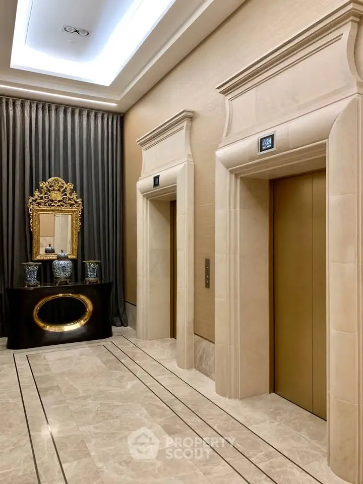 Luxurious building lobby with elegant elevators and ornate mirror decor
