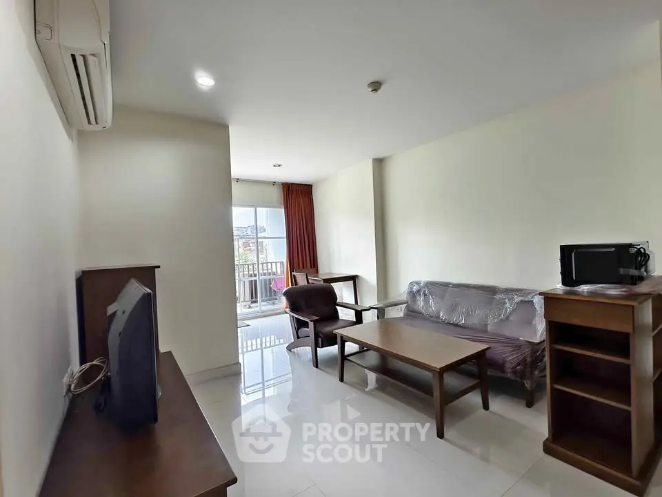 Spacious living room with modern furniture and balcony access in a stylish apartment.