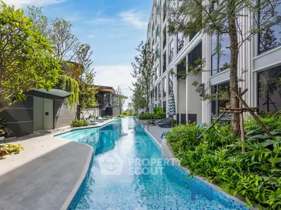 Luxurious modern apartment complex with stunning outdoor pool and lush greenery.