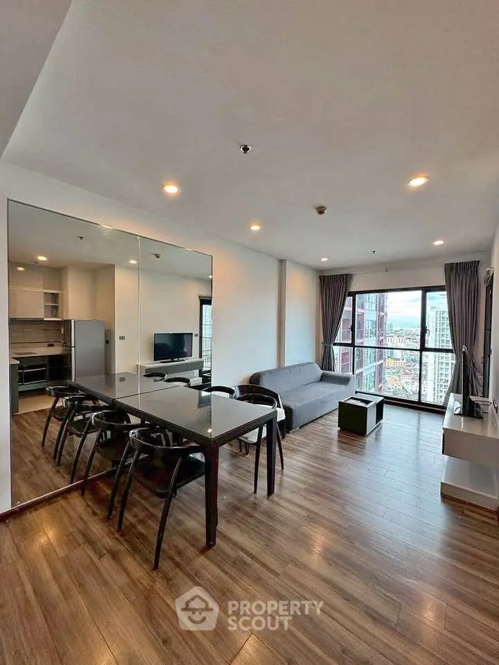 Spacious modern living room with city view, featuring sleek furniture and open layout.