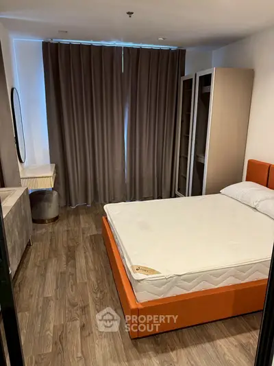 Modern bedroom with stylish orange bed and elegant wooden flooring