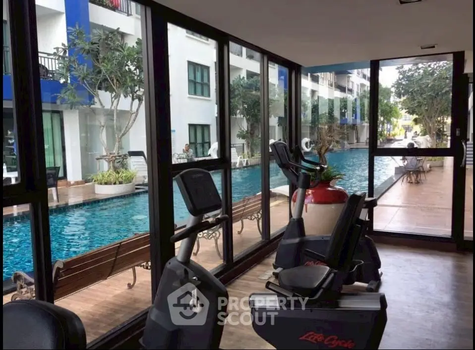 Modern gym with pool view in luxury condominium complex