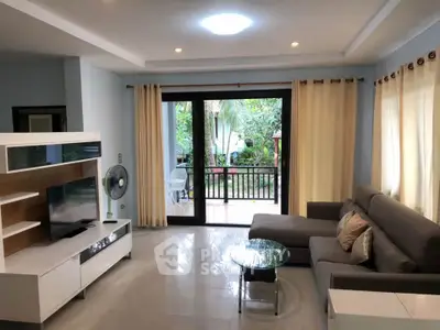 Spacious living room with modern decor and garden view, featuring a cozy sofa and entertainment unit.