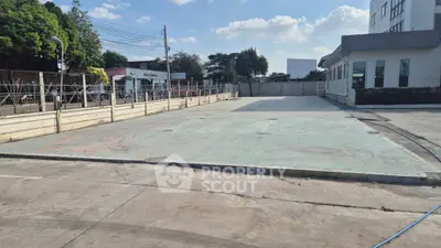 Spacious industrial property with open concrete yard and secure fencing.