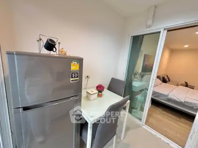 Modern compact kitchen with dining area and view into cozy bedroom