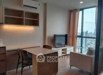 Modern living room with city view, featuring sleek furniture and large windows for natural light.