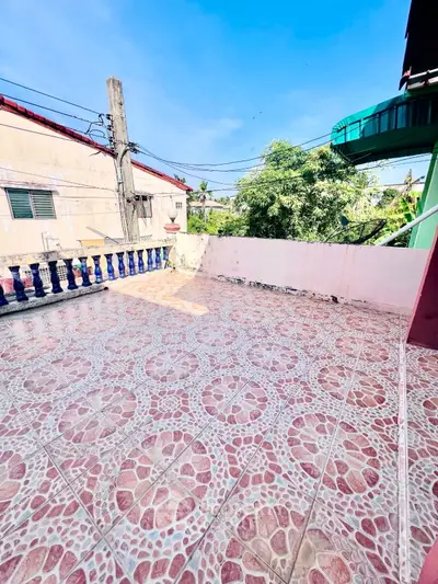 Spacious tiled balcony with vibrant patterns and clear blue sky view.