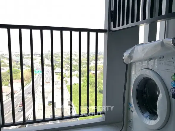 Balcony with washing machine and city view, ideal for urban living convenience.