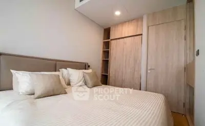 Modern bedroom with cozy bed and built-in wooden wardrobe in a stylish apartment.
