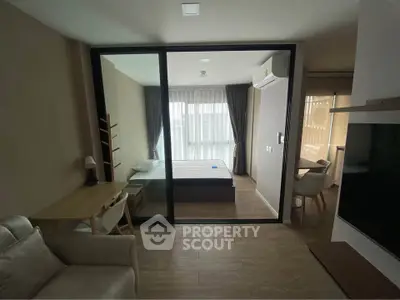 Modern studio apartment with glass partition, cozy living area, and natural light.