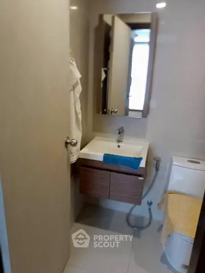 Modern bathroom with sleek fixtures and compact design, featuring a stylish vanity and contemporary toilet.