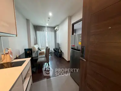 Modern apartment interior with open kitchen and cozy living area, featuring sleek furniture and natural light.