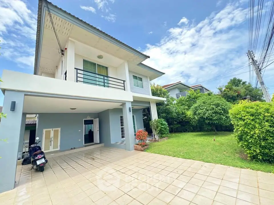 Modern two-story house with spacious driveway and lush garden in a serene neighborhood.