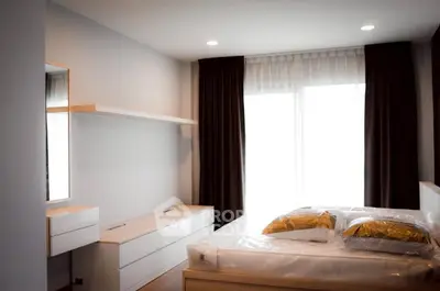 Modern bedroom with sleek furniture and large window for natural light.