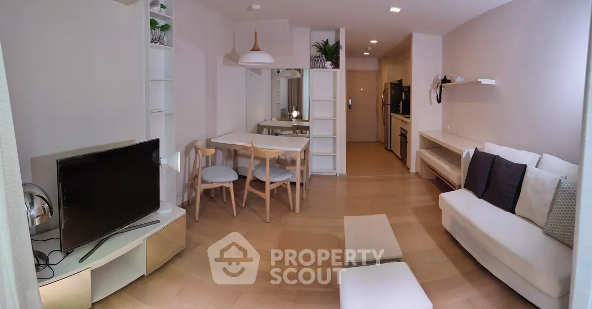 Modern living room with cozy seating and dining area, featuring sleek wooden flooring and stylish decor.