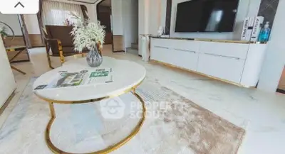 Luxurious living room with modern decor, featuring a sleek TV unit and elegant coffee table.