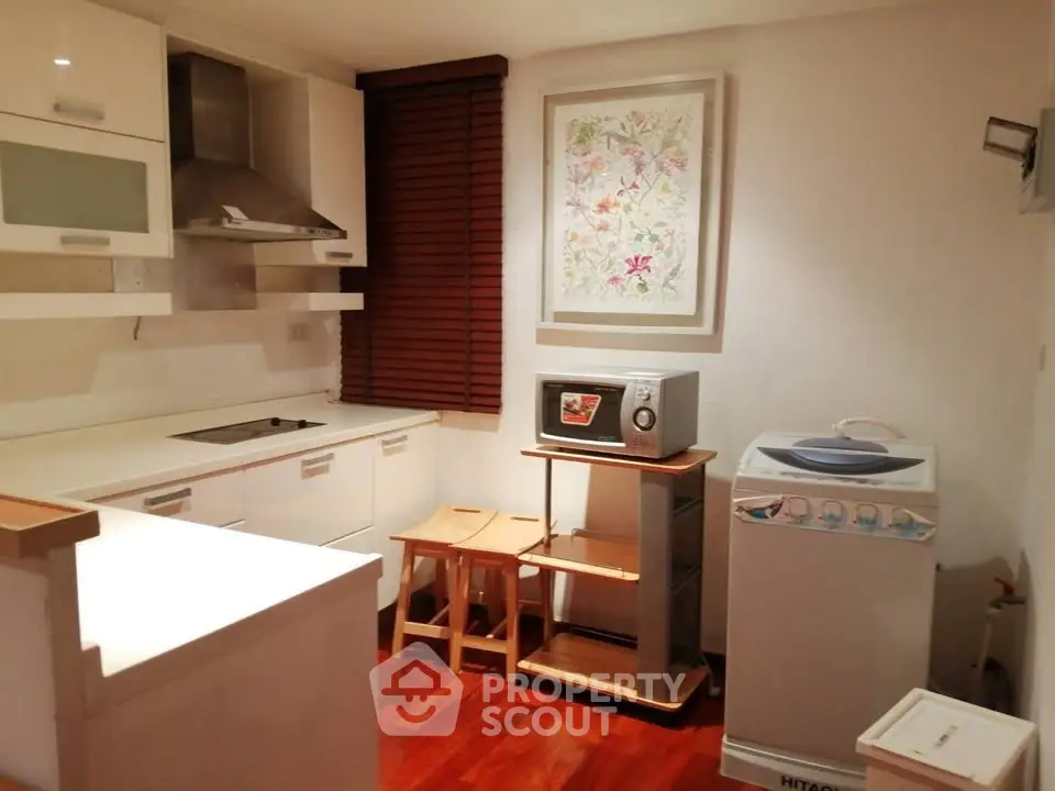Cozy kitchen with modern appliances and washing machine in a compact layout.