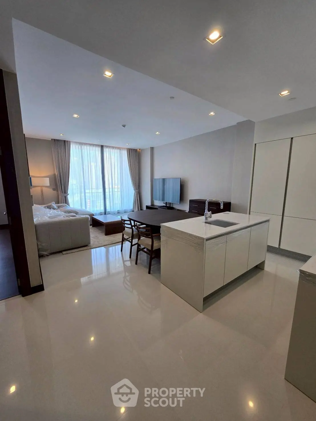 Spacious modern living room with open kitchen and large windows in luxury apartment