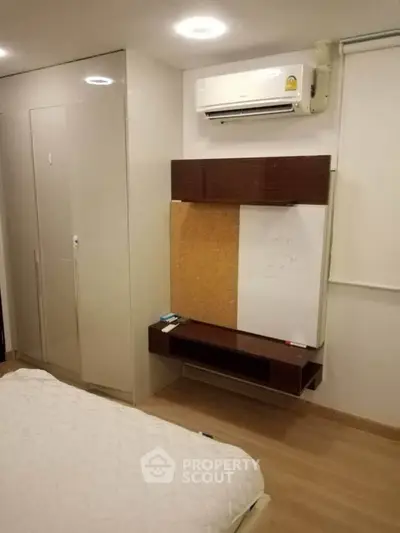Modern bedroom with built-in wardrobe and air conditioning unit