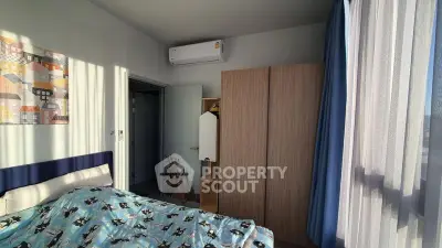 Cozy bedroom with natural light, featuring a wardrobe and air conditioning, perfect for relaxation.