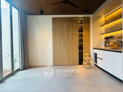 Modern kitchen with sleek cabinetry and open layout, featuring stylish lighting and large windows for natural light.