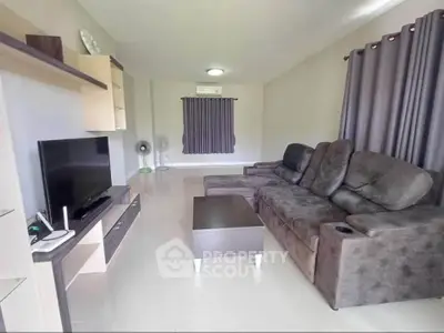 Spacious living room with modern furniture and entertainment setup.