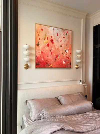 Elegant bedroom with modern art and stylish lighting, perfect for a cozy retreat.