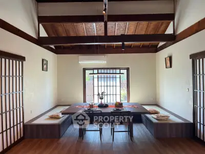 Elegant dining room with wooden beams and traditional Japanese sliding doors, creating a serene and inviting atmosphere.
