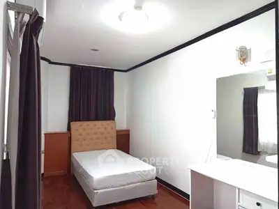 Cozy bedroom with single bed and large mirror, perfect for minimalist living.