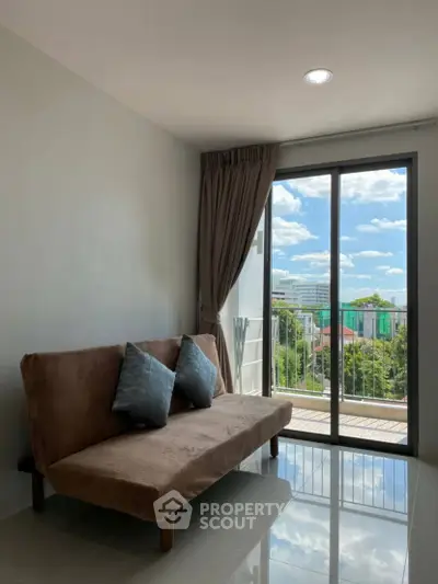 Bright living room with cozy sofa and balcony view