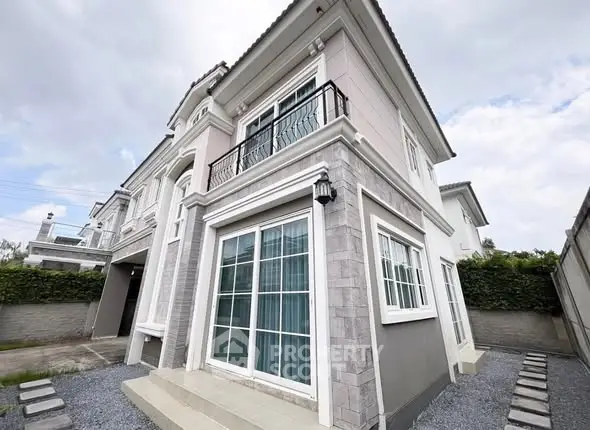 Elegant two-story house with modern facade and large windows.
