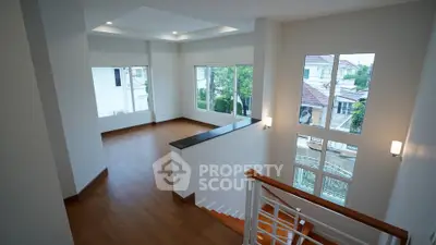 Spacious modern living room with large windows and wooden flooring