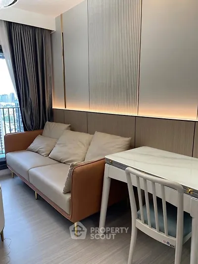 Modern living room with stylish sofa and elegant dining table, featuring a city view from the balcony.