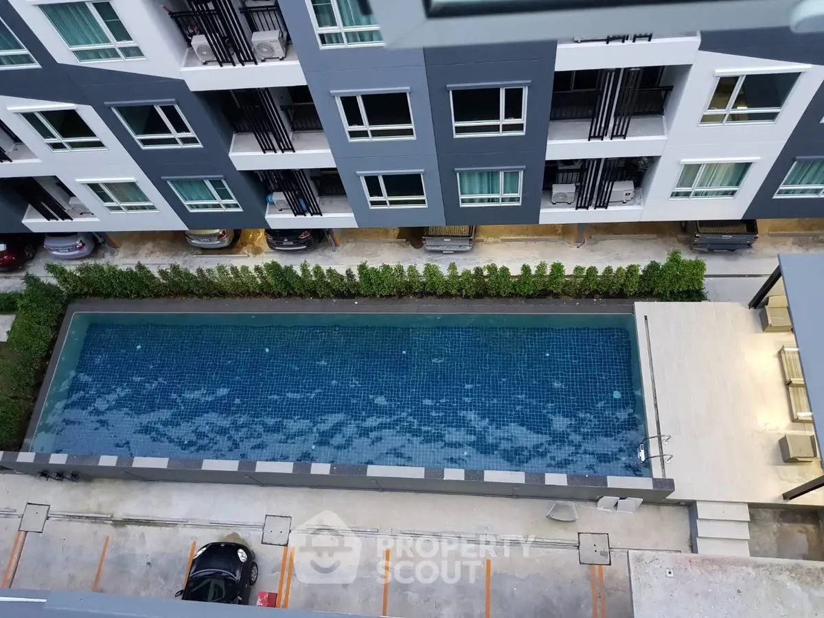 Modern apartment building with a sleek swimming pool view from above.