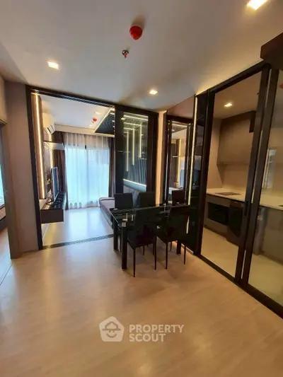 Modern open-plan living and dining area with sleek kitchen in a stylish apartment.
