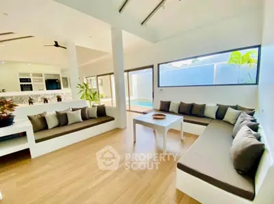 Spacious modern living room with pool view and stylish seating area