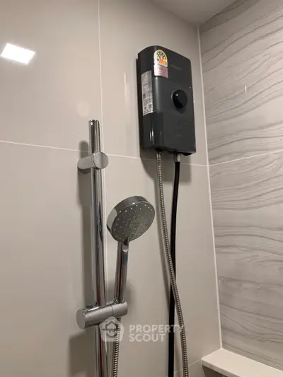 Modern bathroom with sleek showerhead and water heater, featuring elegant tile design.