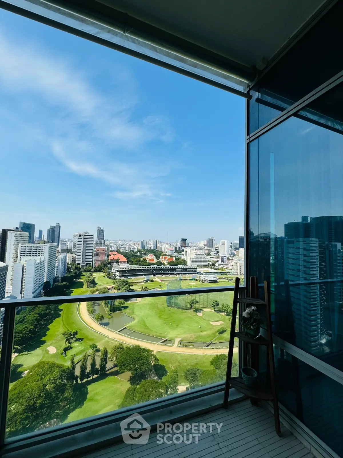 Stunning cityscape view from a high-rise balcony overlooking a lush golf course.