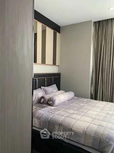 Modern bedroom with stylish decor and cozy bedding in a contemporary apartment.