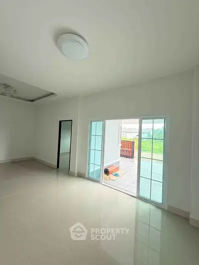 Spacious living room with sliding glass doors leading to a bright outdoor area.