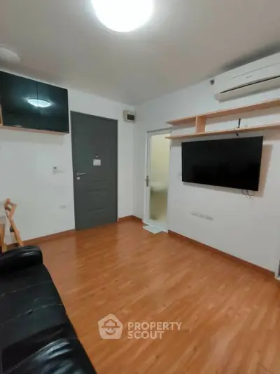 Modern living room with sleek wooden flooring and wall-mounted TV