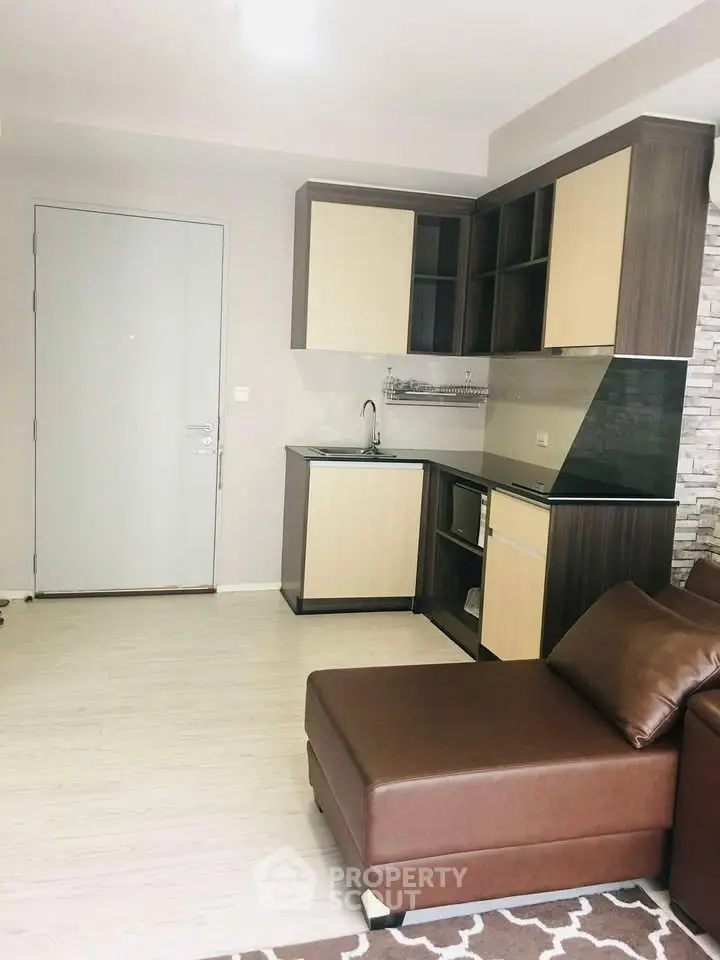 Modern living room with sleek kitchen and stylish brown sofa