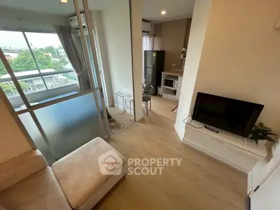 Modern living room with open kitchen and balcony view in a stylish apartment.